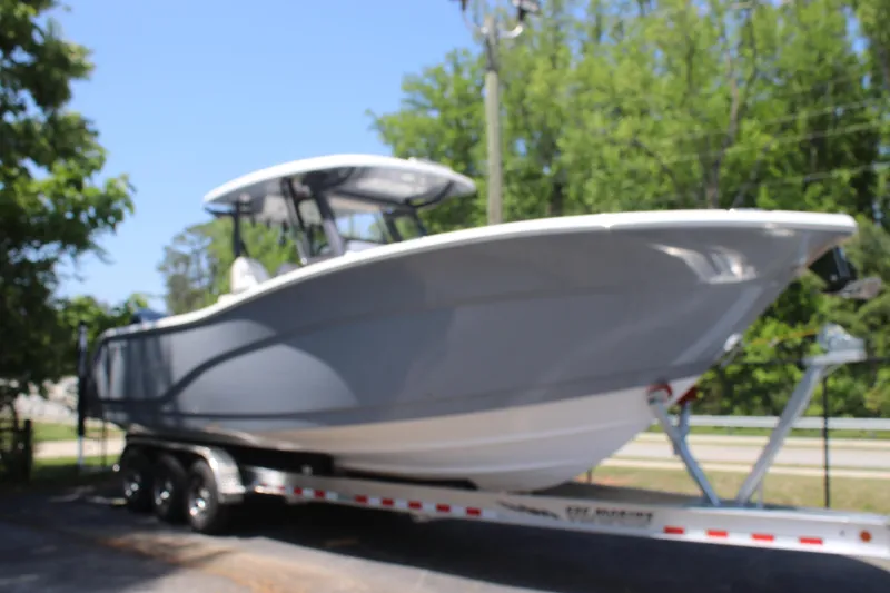 Slide: The Image of 2025 Sea Fox 328 Commander boat on trailer, surrounded by trees. - 10