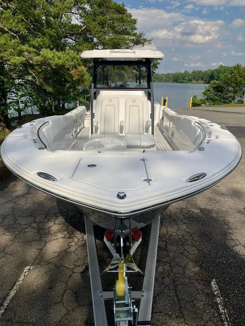 Slide: The Image of 2025 Sea Fox 328 Commander boat on trailer, surrounded by trees and lake view. - 4