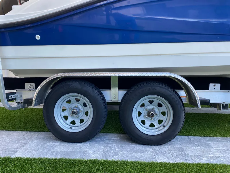 Slide: The Image of Trailer wheels of a 2020 Sea Ray SPX 210 Outboard boat on grass. - 4