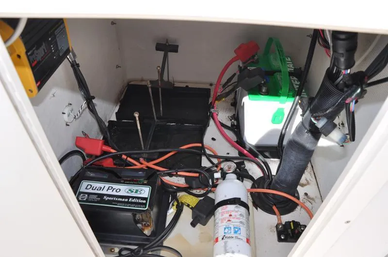 Slide: The Image of 2005 Pathfinder 2200 boat battery compartment with wiring, charger, and fire extinguisher. - 22