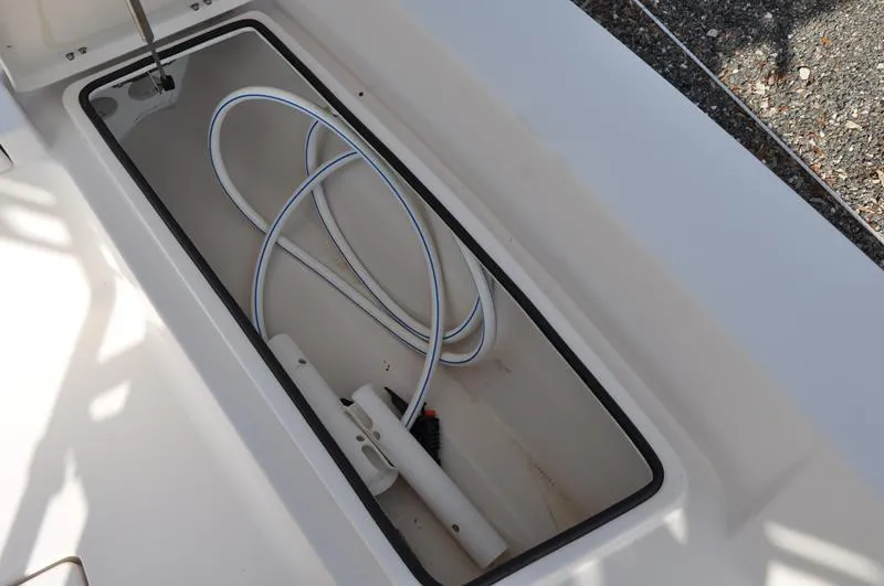 Slide: The Image of Storage compartment of a 2005 Pathfinder 2200 boat with coiled hose inside. - 27