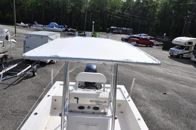 Slide: The Image of 2005 Pathfinder 2200 boat with T-top in a parking lot, surrounded by vehicles and trailers. - 33