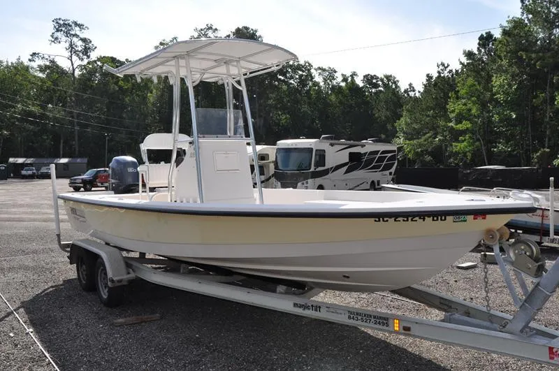 Slide: The Image of 2005 Pathfinder 2200 boat on trailer in parking lot with trees and RVs in background. - 5