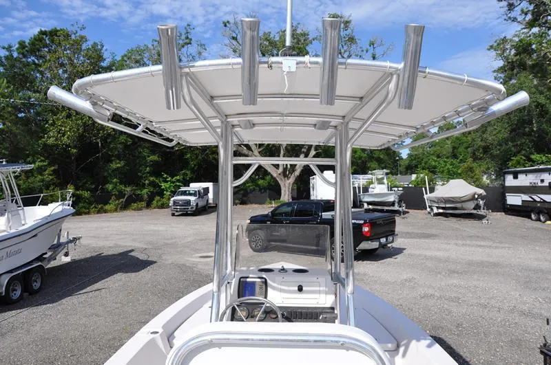Slide: The Image of 2005 Pathfinder 2200 boat with T-top in a parking area, surrounded by trees and vehicles. - 8