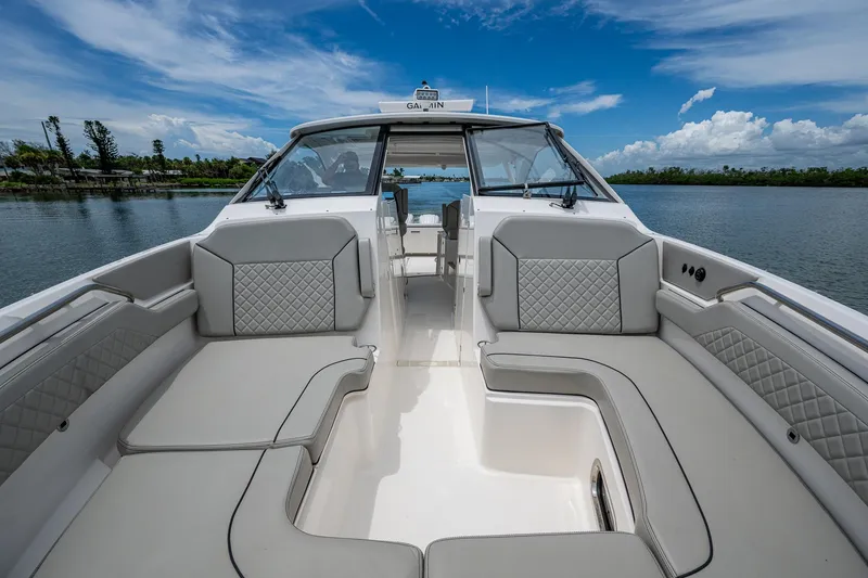 Slide: The Image of 2023 Pursuit DC 365 Dual Console boat interior with luxurious seating and scenic water view. - 10