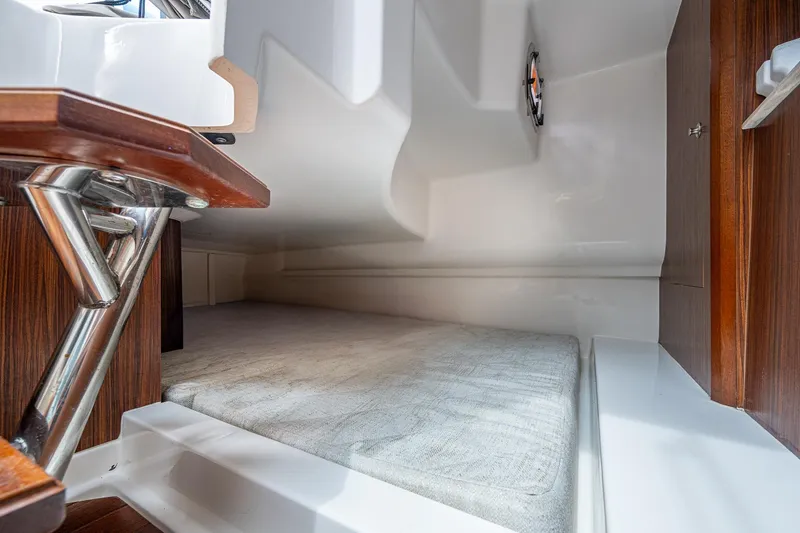 Slide: The Image of 2023 Pursuit DC 365 Dual Console cabin interior with wood accents and cushioned seating. - 14