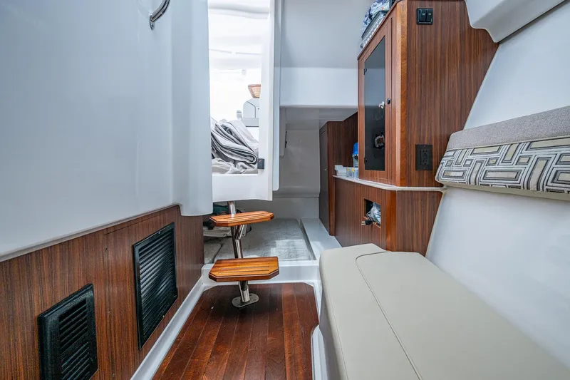 Slide: The Image of 2023 Pursuit DC 365 Dual Console interior with wood accents and seating. - 17