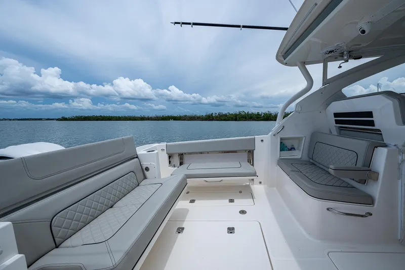 Slide: The Image of 2023 Pursuit DC 365 Dual Console boat interior with gray seating, open water view. - 20