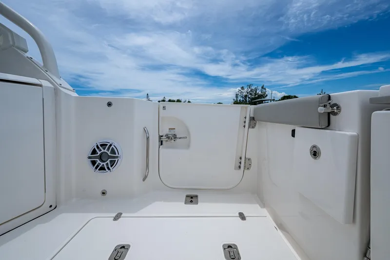 Slide: The Image of 2023 Pursuit DC 365 Dual Console boat interior with speaker, hatch, and clear sky. - 23