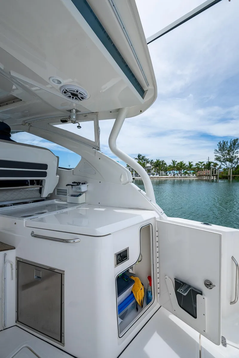 Slide: The Image of 2023 Pursuit DC 365 Dual Console boat interior with storage and scenic water view. - 29