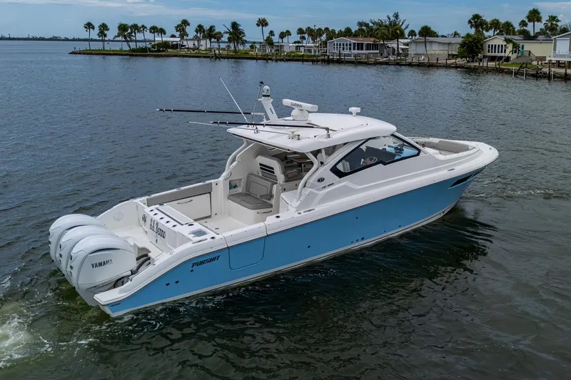 Slide: The Image of 2023 Pursuit DC 365 Dual Console boat on calm water, featuring triple Yamaha engines. - 3