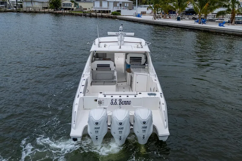 Slide: The Image of 2023 Pursuit DC 365 Dual Console boat with triple engines on water. - 4