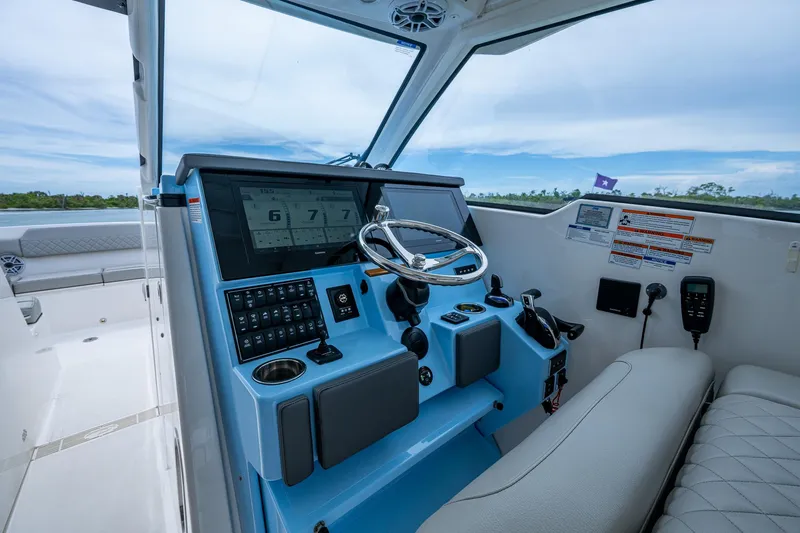 Slide: The Image of 2023 Pursuit DC 365 Dual Console boat cockpit with modern controls and steering wheel. - 41