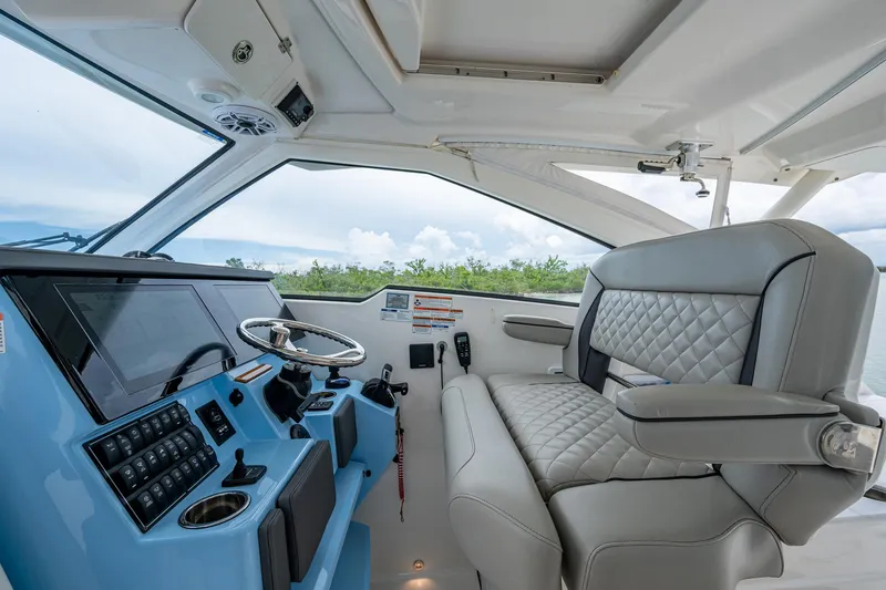 Slide: The Image of 2023 Pursuit DC 365 Dual Console interior with modern helm and luxurious seating. - 42