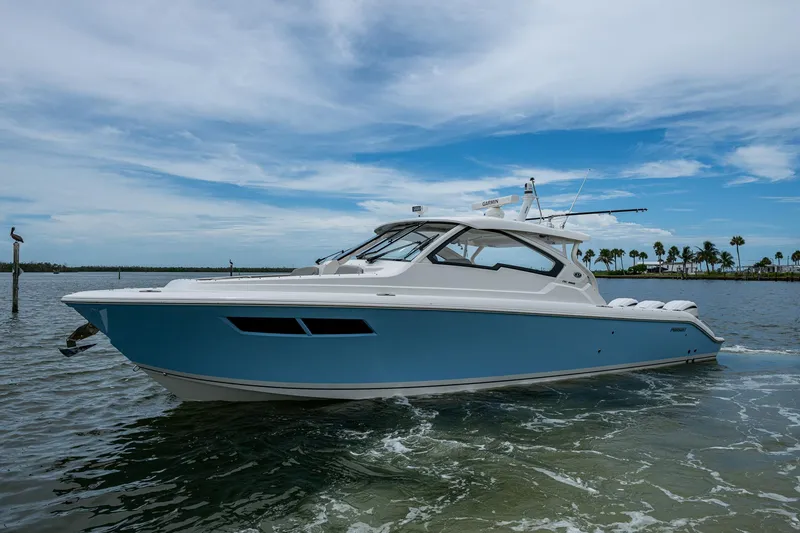 Slide: The Image of 2023 Pursuit DC 365 Dual Console boat on calm water under a blue sky. - 46
