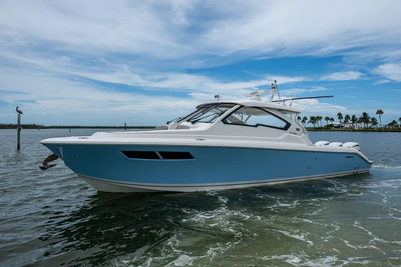 Slide: The Image of 2023 Pursuit DC 365 Dual Console boat on calm water under a blue sky. - 47