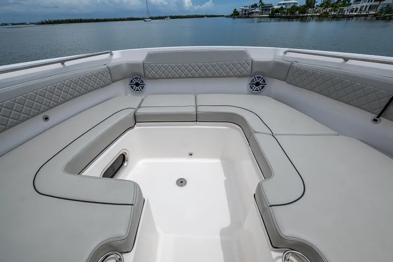 Slide: The Image of 2023 Pursuit DC 365 Dual Console boat interior with cushioned seating and scenic water view. - 7