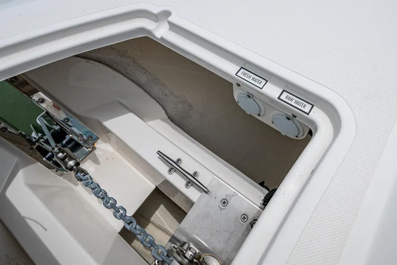 Slide: The Image of 2023 Pursuit DC 365 Dual Console anchor compartment with fresh and raw water outlets. - 9