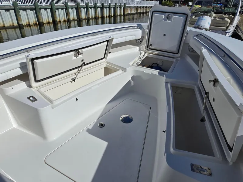 Slide: The Image of 2017 Regulator 28 boat with open storage compartments, docked by a wooden pier. - 11