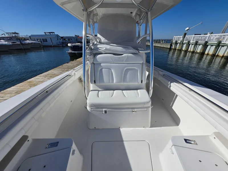 Slide: The Image of 2017 Regulator 28 boat interior at dock, featuring white seating and clear blue sky. - 16