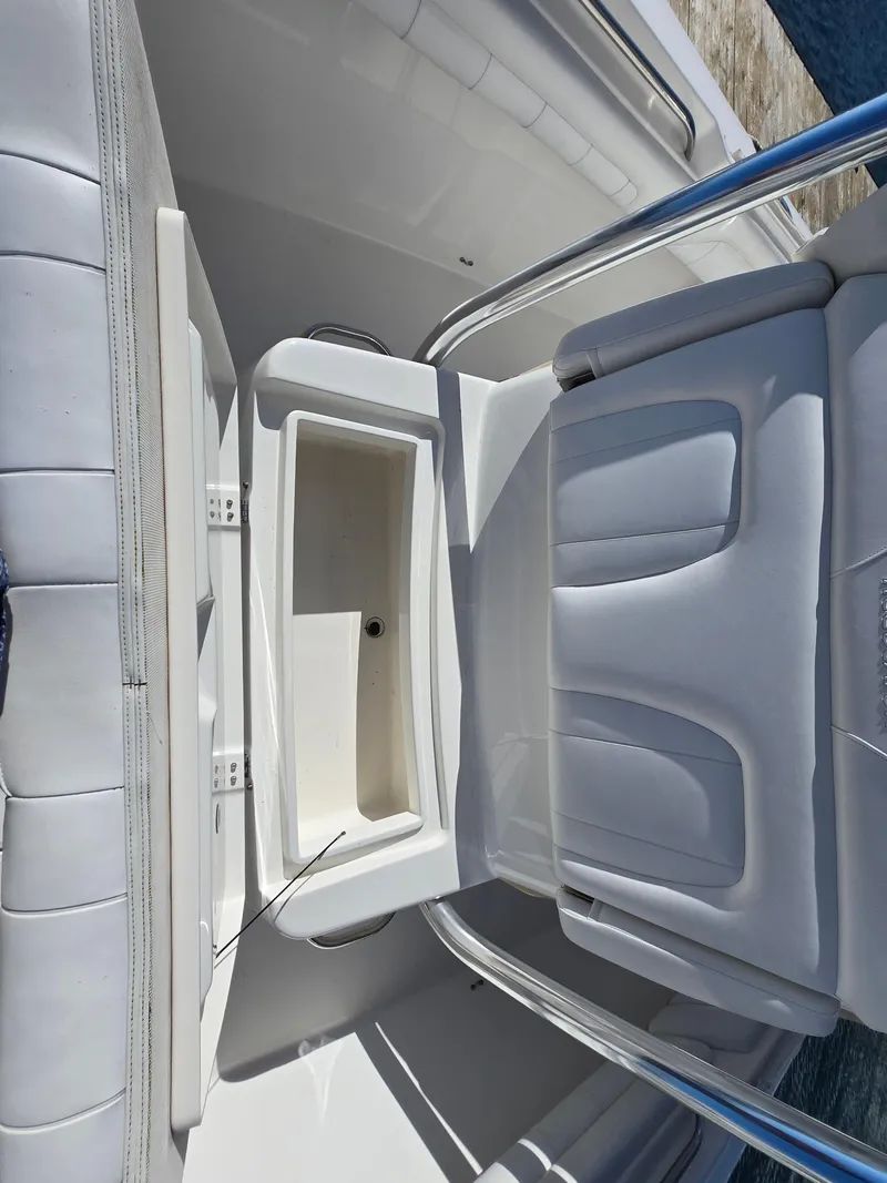 Slide: The Image of 2017 Regulator 28 boat interior with white cushioned seating and storage compartment. - 17