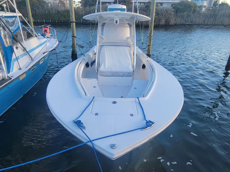 Slide: The Image of 2017 Regulator 28 boat docked, front view, with blue ropes and calm water. - 2