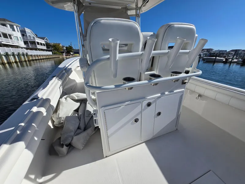 Slide: The Image of 2017 Regulator 28 boat interior with rod holders and storage, docked near waterfront homes. - 27