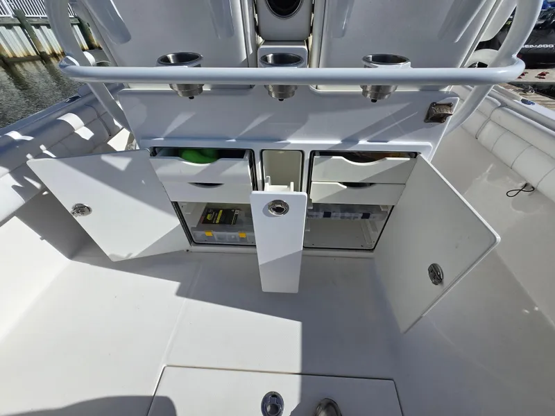 Slide: The Image of 2017 Regulator 28 boat storage compartments with open doors and visible drawers. - 29