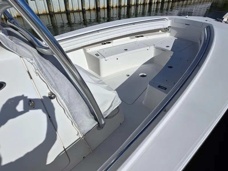 Slide: The Image of 2017 Regulator 28 boat interior with seating and storage, docked by wooden barriers. - 8