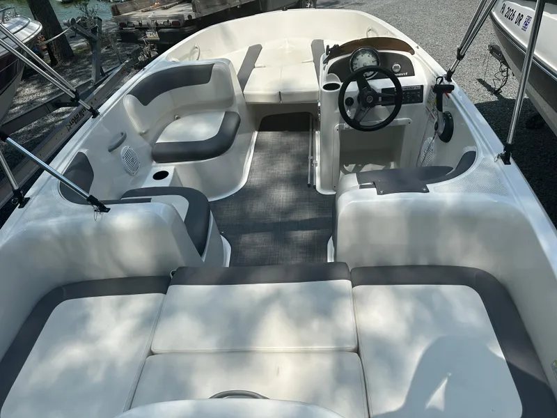 Slide: The Image of 2019 Bayliner Element E16 boat interior with seating and steering wheel. - 12