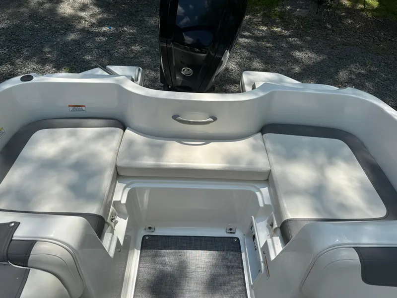 Slide: The Image of 2019 Bayliner Element E16 boat interior with cushioned seating and motor view. - 6