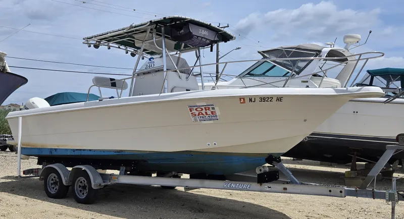 The Image of 1995 Pro-Line 240 Center Console boat on trailer, for sale, with clear sky background. - 0
