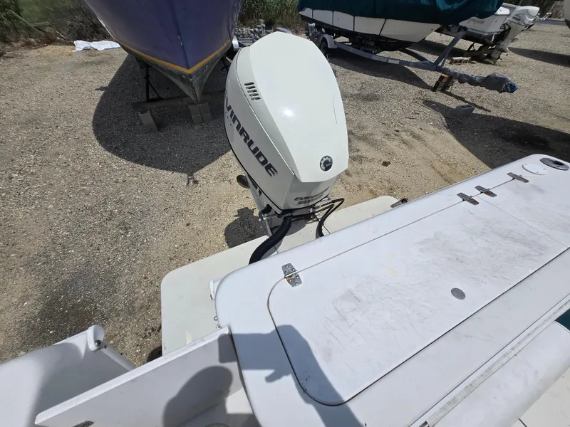 Slide: The Image of 1995 Pro-Line 240 Center Console boat with Evinrude outboard motor, parked on gravel. - 11