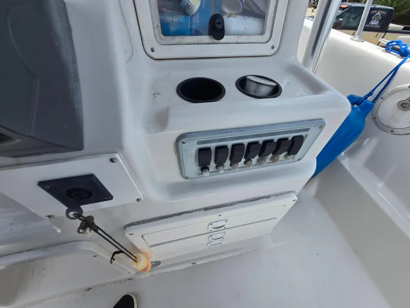 Slide: The Image of 1995 Pro-Line 240 Center Console boat dashboard with switches and storage compartments. - 17