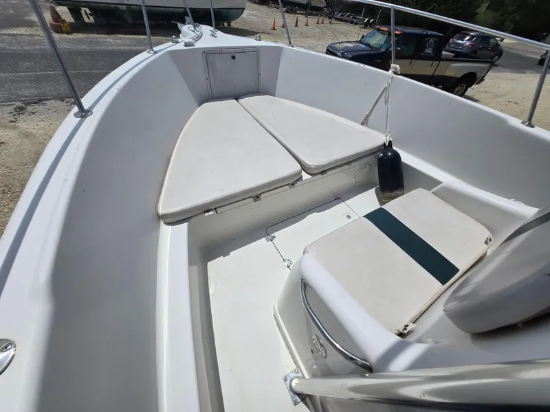 Slide: The Image of 1995 Pro-Line 240 Center Console boat interior with cushioned seating and railing. - 19