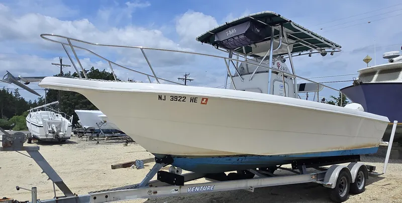 Slide: The Image of 1995 Pro-Line 240 Center Console boat on trailer, parked outdoors under a blue sky. - 2