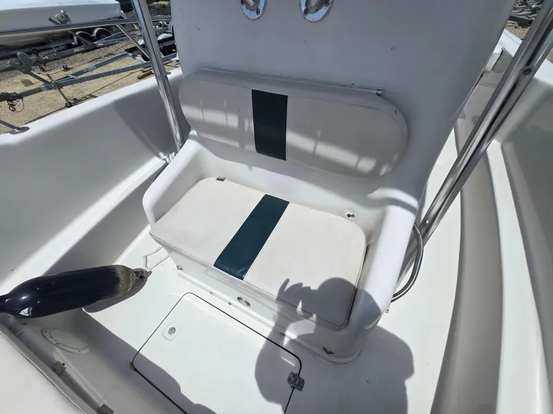 Slide: The Image of 1995 Pro-Line 240 Center Console boat seat with white and green cushions. - 21