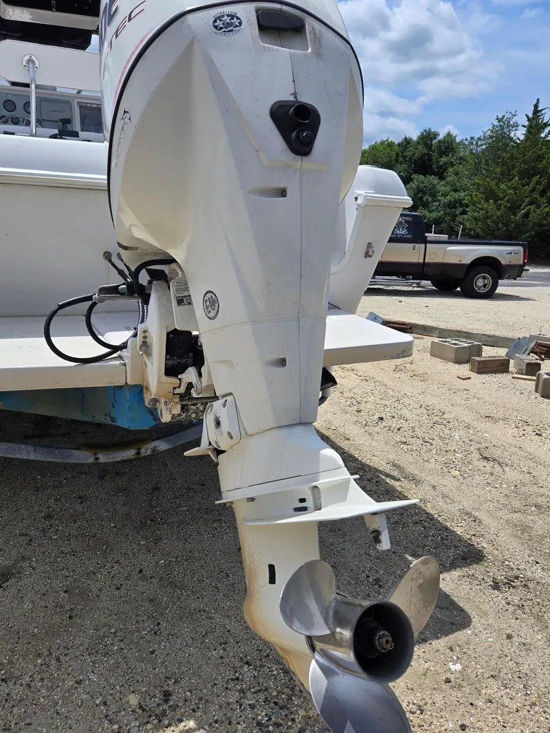Slide: The Image of 1995 Pro-Line 240 Center Console boat with outboard motor on a sandy surface. - 22