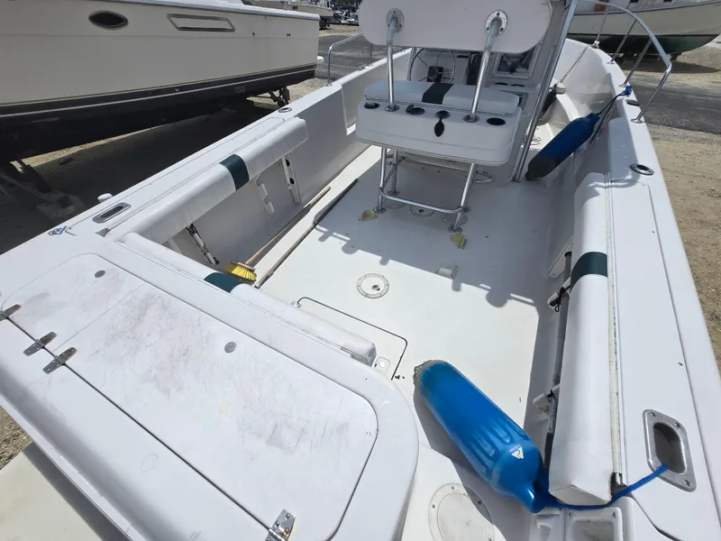 Slide: The Image of 1995 Pro-Line 240 Center Console boat interior with seating and console, docked outdoors. - 3