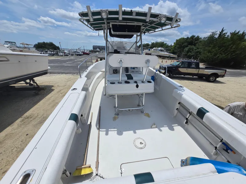 Slide: The Image of 1995 Pro-Line 240 Center Console boat with open deck and T-top, parked on a sunny day. - 8