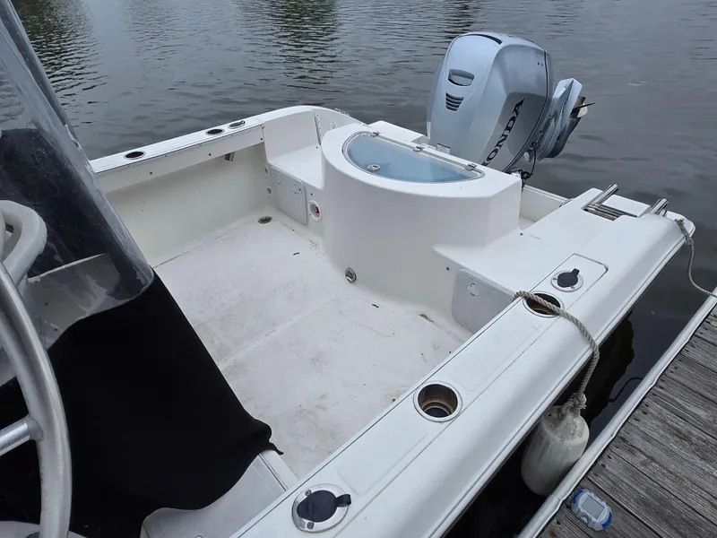 Slide: The Image of 2010 Sea Fox 216 Walk Around boat with Honda outboard motor, docked on calm water. - 3