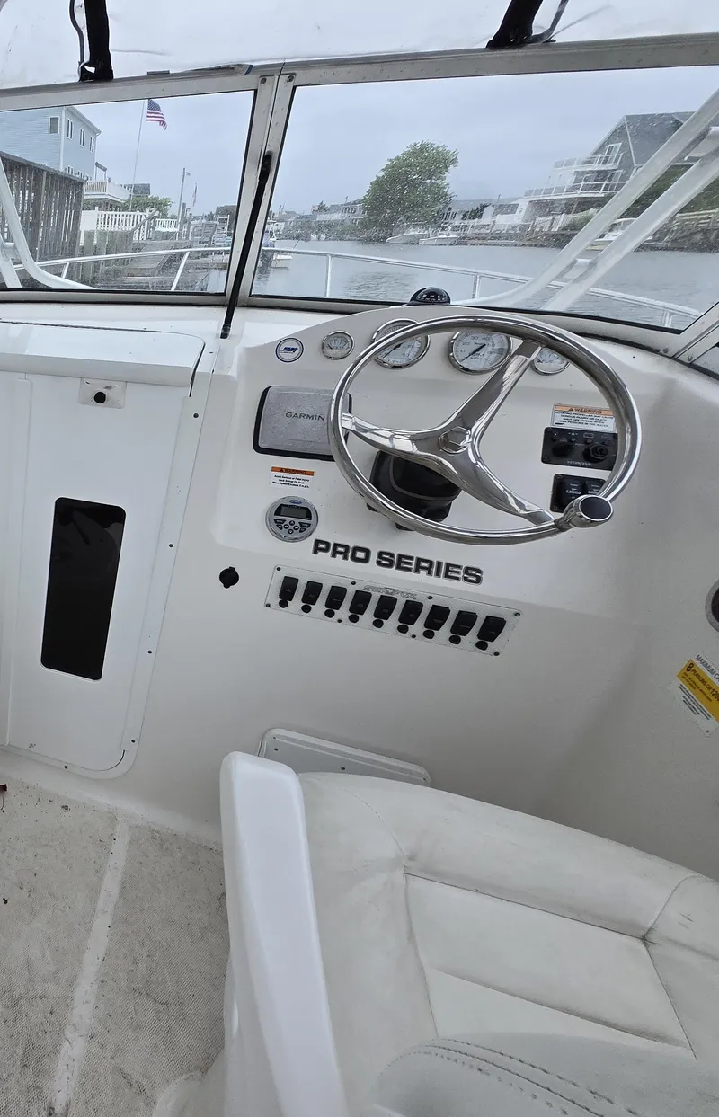 Slide: The Image of Interior view of 2010 Sea Fox 216 Walk Around boat cockpit with steering wheel and controls. - 7