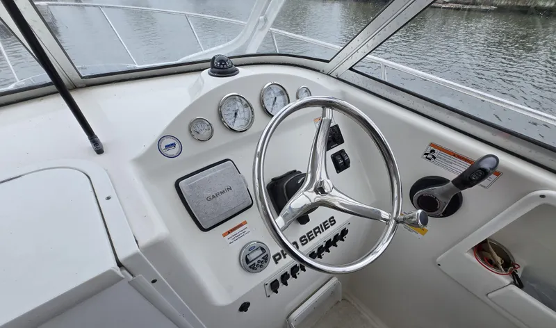 Slide: The Image of 2010 Sea Fox 216 Walk Around boat dashboard with steering wheel and Garmin navigation system. - 9