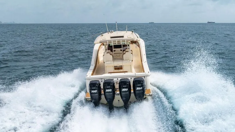Slide: The Image of 2018 Scout 420 LXF boat cruising on open water with four engines. - 14