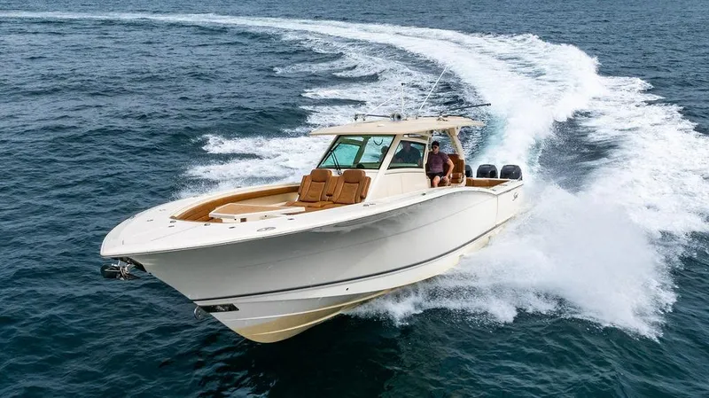 Slide: The Image of 2018 Scout 420 LXF boat cruising on open water, creating a dynamic wake. - 17