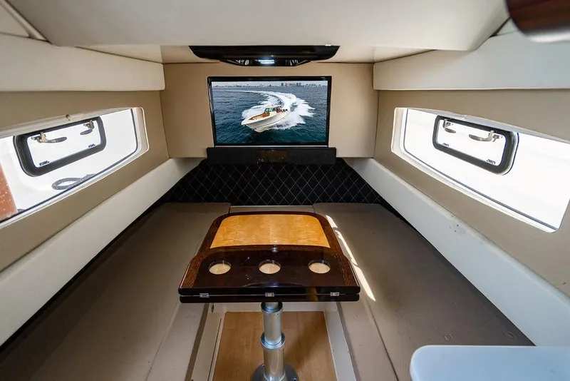 Slide: The Image of Interior of 2018 Scout 420 LXF boat with TV and table setup. - 23