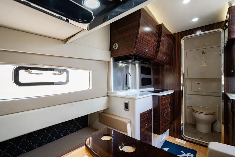 Slide: The Image of Luxurious interior of a 2018 Scout 420 LXF boat featuring a kitchenette and bathroom. - 28