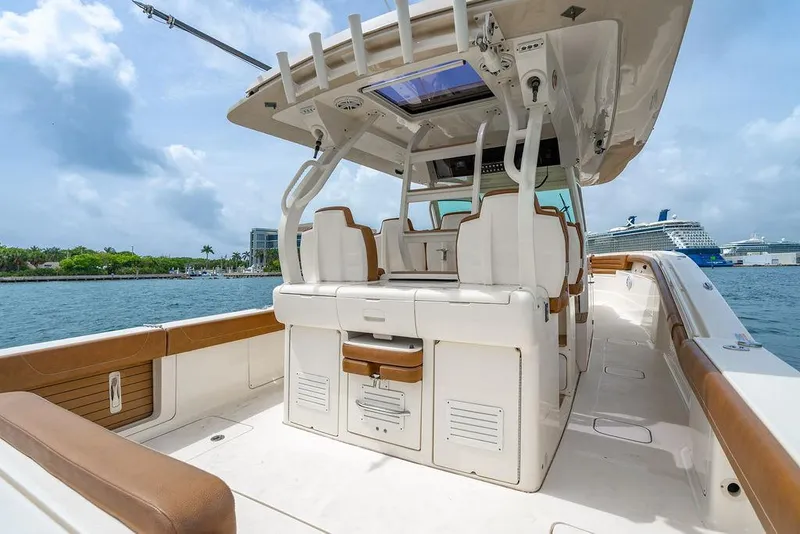 Slide: The Image of 2018 Scout 420 LXF boat interior with seating, docked near cruise ships. - 45