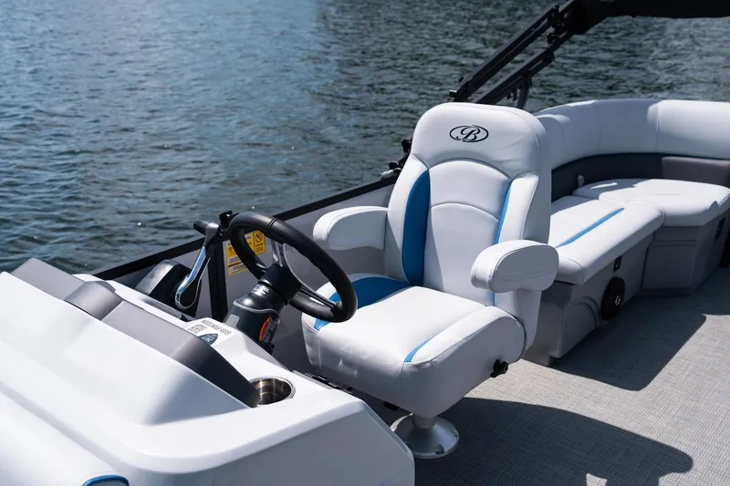 Slide: The Image of 2025 Bentley Pontoons 223 Bolt interior with steering console on a lake. - 2