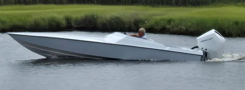 The Image of Sleek 1991 Activator 22 speedboat cruising on a calm river with lush green banks. - 0